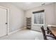 A simple carpeted bedroom features a shelving unit, window, chair, and desk at 6105 N Hanover St, Denver, CO 80238