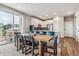 Open-concept dining area with a large wooden table, black chairs, counter seating, and sliding doors to the outside patio at 6105 N Hanover St, Denver, CO 80238