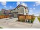 Modern two-story house with neutral siding, double garage, fenced front yard, and well-maintained landscaping at 6105 N Hanover St, Denver, CO 80238