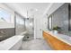 Bright bathroom with tub, double sinks, and a glass enclosed shower with tiled surround at 553 Monroe St, Denver, CO 80206