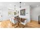 Bright dining room with modern lighting fixtures, a wood table, and white chairs at 553 Monroe St, Denver, CO 80206