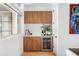 Wet bar with wood cabinets, a wine cooler, and white countertops at 553 Monroe St, Denver, CO 80206