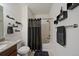 Bathroom featuring a toilet, shower and tub combo with a dark shower curtain and towel rack at 4474 Copeland Cir # 102, Highlands Ranch, CO 80126