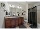 Bathroom featuring double sink vanity with granite countertop and framed mirror with shower and tub at 4474 Copeland Cir # 102, Highlands Ranch, CO 80126