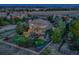 Dusk aerial view of the home's backyard with mature trees, fire pit, lush lawn, and neighbor views at 5603 Twilight Way, Parker, CO 80134
