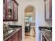 A butler's pantry featuring dark granite countertops and custom wooden cabinets with clear glass panels at 5603 Twilight Way, Parker, CO 80134