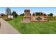 Attractive community entrance with stone signage, manicured lawn and directional sales office arrow at 5603 Twilight Way, Parker, CO 80134