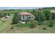 Expansive exterior of home features lush lawn, mature trees and landscaping, and views of surrounding community at 5603 Twilight Way, Parker, CO 80134
