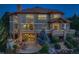 Back of home featuring patio with string lights, outdoor fireplace, and lush garden views for relaxing evenings at 5603 Twilight Way, Parker, CO 80134
