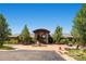 Stunning home exterior with stone accents, mature trees, a circular driveway, and desert landscaping at 5603 Twilight Way, Parker, CO 80134