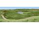 Expansive golf course with lush green fairways, a serene pond, and distant views of rolling hills at 5603 Twilight Way, Parker, CO 80134