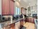 Well-lit kitchen featuring dark wood cabinets, granite counters, stainless steel appliances, and modern fixtures at 5603 Twilight Way, Parker, CO 80134
