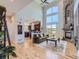 Open-concept living room with fireplace, hardwood floors, high ceilings, and views to the kitchen and outdoors at 5603 Twilight Way, Parker, CO 80134