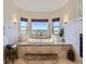 Serene main bathroom with a soaking tub, fireplace, step-up platform, and scenic window views at 5603 Twilight Way, Parker, CO 80134