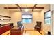 A well-lit home office with wood floors, a desk, shelves and windows offering exterior views at 5603 Twilight Way, Parker, CO 80134