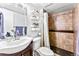 Well-lit bathroom featuring a shower-tub combo, vanity with mirror, and shelving for storage at 17177 E Milan Cir, Aurora, CO 80013