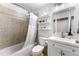 Bright bathroom featuring a shower-tub combo, vanity with mirror, and shelving for storage at 17177 E Milan Cir, Aurora, CO 80013