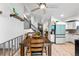 Bright dining room featuring wood table, a statement ceiling fan, and a seamless transition into the modern kitchen area at 17177 E Milan Cir, Aurora, CO 80013