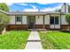 Inviting entryway with a well-kept lawn, brick details, and a freshly painted front door at 17177 E Milan Cir, Aurora, CO 80013