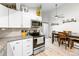 Bright kitchen featuring white cabinets, stainless steel appliances, granite countertops, and stylish backsplash at 17177 E Milan Cir, Aurora, CO 80013