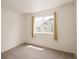 Empty, carpeted bedroom with large window and neutral paint at 805 Summer Hawk Dr # 100, Longmont, CO 80504
