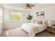 Bright bedroom featuring a ceiling fan, comfortable bed, and a large window overlooking greenery at 805 Summer Hawk Dr # 100, Longmont, CO 80504