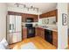 Well-equipped kitchen with stainless steel refrigerator and dark wood cabinetry at 805 Summer Hawk Dr # 100, Longmont, CO 80504