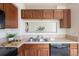 Cozy kitchen with stainless steel sink, black dishwasher, and wood cabinets at 805 Summer Hawk Dr # 100, Longmont, CO 80504