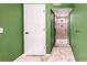 Bathroom with white marble tile floors, green walls, white door, leading to a walk-in shower at 1209 S Flower Cir # C, Lakewood, CO 80232
