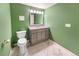 Bathroom features decorative green walls, updated vanity with marble tile floor, and modern toilet at 1209 S Flower Cir # C, Lakewood, CO 80232