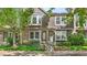 Charming townhouse featuring a brick facade, mature landscaping, and a welcoming entrance at 1209 S Flower Cir # C, Lakewood, CO 80232