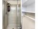 Modern shower featuring glass door, shower head, and built-in niche, complemented by white shelving unit at 1209 S Flower Cir # C, Lakewood, CO 80232