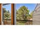 Balcony view of a lush backyard with a large pine tree and a wooden fence at 1209 S Flower Cir # C, Lakewood, CO 80232