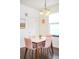 Lovely dining area featuring a white table with four chairs, hardwood floors, and natural light at 2773 Roslyn St, Denver, CO 80238