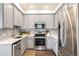 Modern kitchen with stainless steel appliances, grey cabinets, and a stylish backsplash at 2773 Roslyn St, Denver, CO 80238