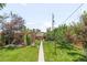 Spacious backyard with a well-manicured lawn, mature trees, and an outdoor patio area at 5044 W Moncrieff Pl, Denver, CO 80212