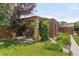 Backyard patio with a pergola, lush greenery, and a brick structure at 5044 W Moncrieff Pl, Denver, CO 80212