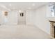 Bright finished basement with white trim, double doors, and stone fireplace at 5044 W Moncrieff Pl, Denver, CO 80212
