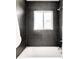 Bathroom with tiled walls, modern shower fixture, and soaking tub at 5044 W Moncrieff Pl, Denver, CO 80212