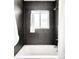 Clean bathroom with a white tub, shower, and gray tiled walls at 5044 W Moncrieff Pl, Denver, CO 80212