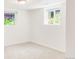 Carpeted bedroom with two bright, sunny windows and white trim at 5044 W Moncrieff Pl, Denver, CO 80212