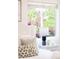Bedroom detail showcases a bedside table with a lamp and a view to the outside at 5044 W Moncrieff Pl, Denver, CO 80212