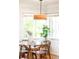Dining room with modern lighting and an adjacent view to a landscaped yard at 5044 W Moncrieff Pl, Denver, CO 80212