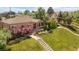 Aerial view showcasing the charming brick home, lush landscaping, and welcoming front porch at 5044 W Moncrieff Pl, Denver, CO 80212