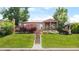 Charming brick home with a covered front porch and beautiful landscaping at 5044 W Moncrieff Pl, Denver, CO 80212