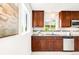 Charming kitchen featuring wooden cabinets, stainless steel appliances, and a mosaic backsplash at 5044 W Moncrieff Pl, Denver, CO 80212