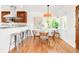 Kitchen and dining area featuring stainless steel appliances, wood cabinetry, and hardwood floors at 5044 W Moncrieff Pl, Denver, CO 80212