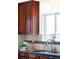 Close up on kitchen sink with granite countertops, tile backsplash, and wooden cabinetry at 5044 W Moncrieff Pl, Denver, CO 80212