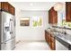 Well-lit kitchen with stainless steel refrigerator and dark stone countertops at 5044 W Moncrieff Pl, Denver, CO 80212