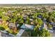 A drone shot of a residential home surrounded by mature trees, with a view of the city skyline in the distance at 5054 W 61St Dr, Arvada, CO 80003